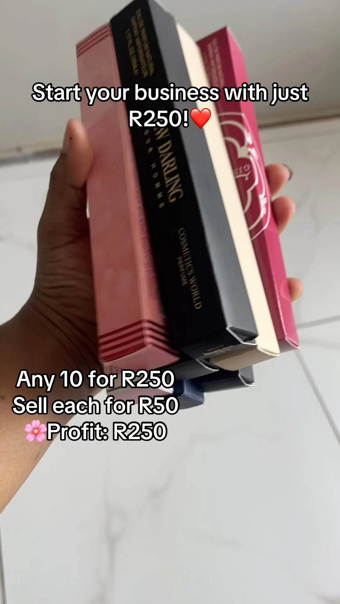 Assorted boxed pocket perfumes held in one hand